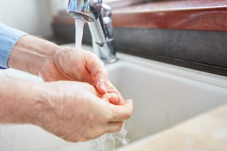 Senior washing hands in order to maintain proper personal hygiene.