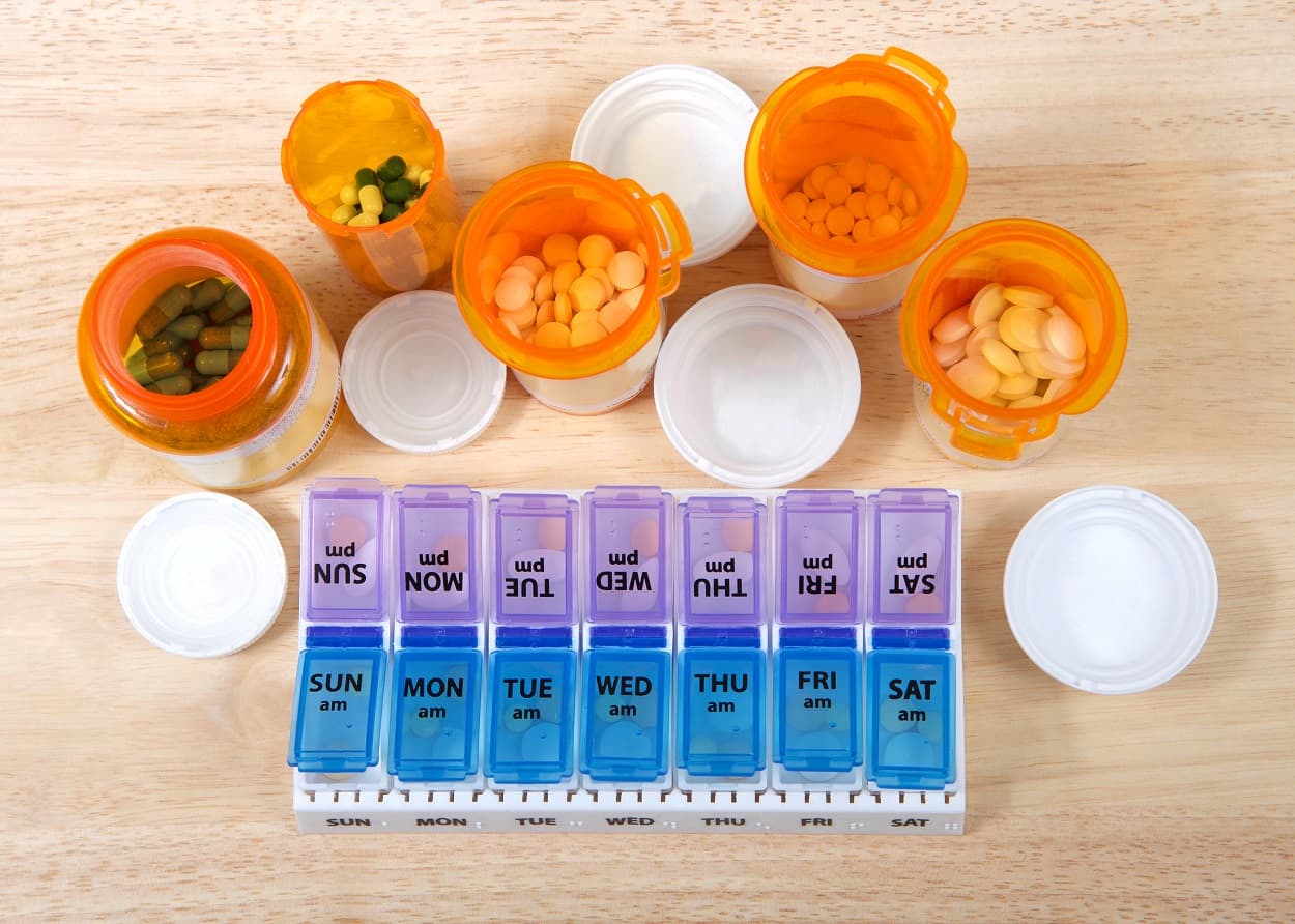 photo of pill bottles and container to organize the medication