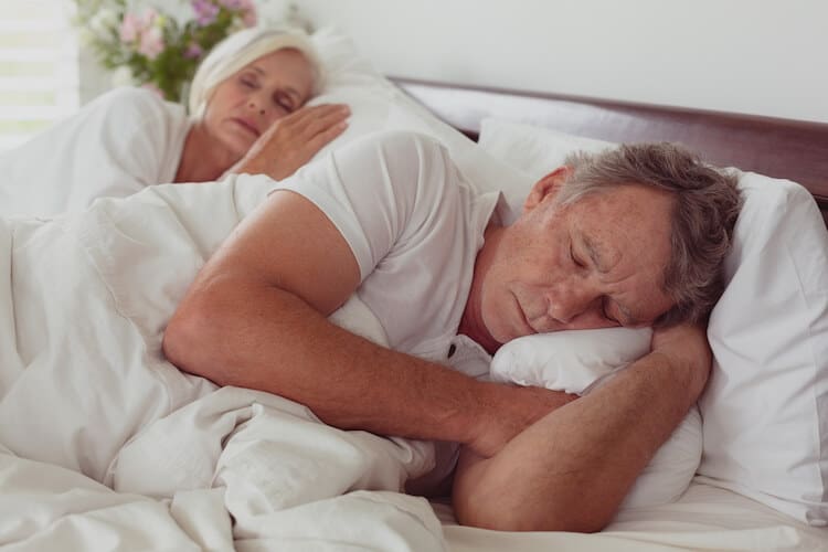 Senior couple sleeping in bed.