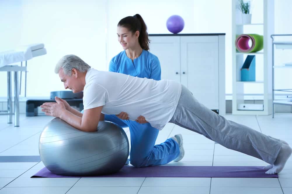 Physiotherapist works with a senior man