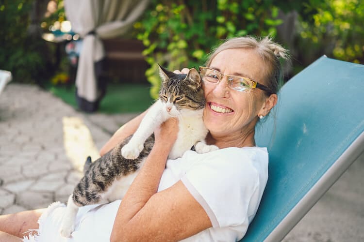 A senior woman relaxes with her cat.