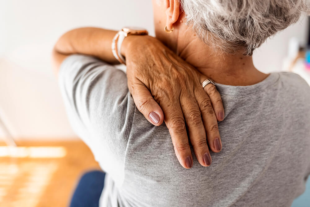 older woman massaging shoulder