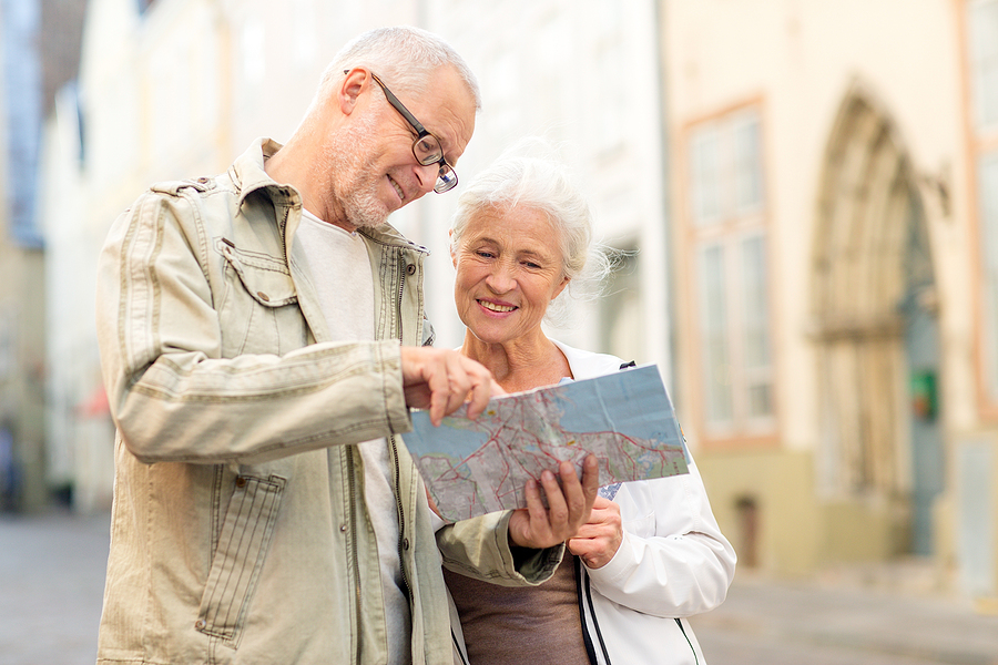 A senior couple traveling and looking at a map.