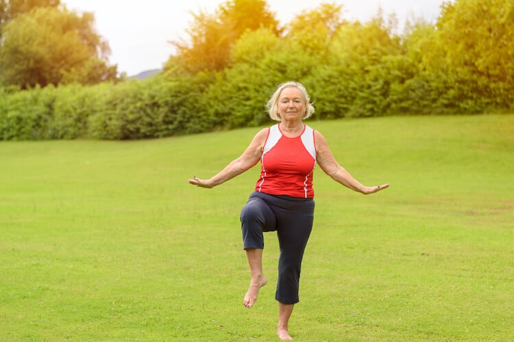 Woman performing senior exercises for balance at a park.