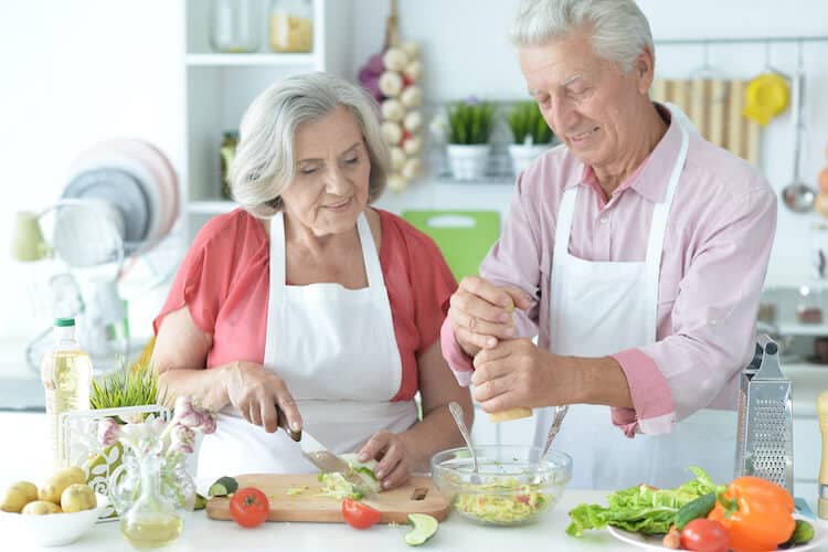Senior couple cooking a meal together to celebrate National Nutrition Month.