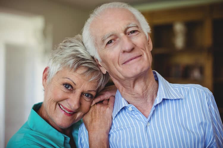 A senior couple smiling at the camera.