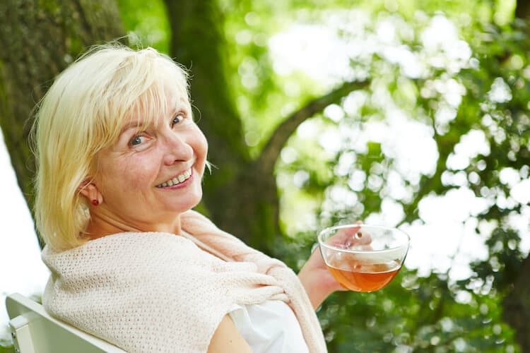 Senior woman drinking a ginger tea to help boost her immune system.