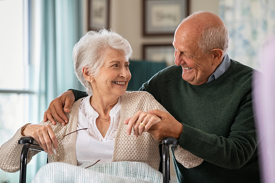 A senior man spending time with his senior wife in a wheelchair
